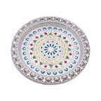 Silver pooja thali showing intricate design.